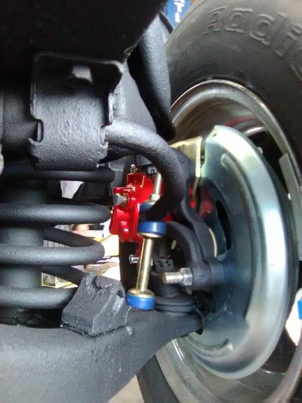 Close-up of fresh suspension and brake components under a vehicle